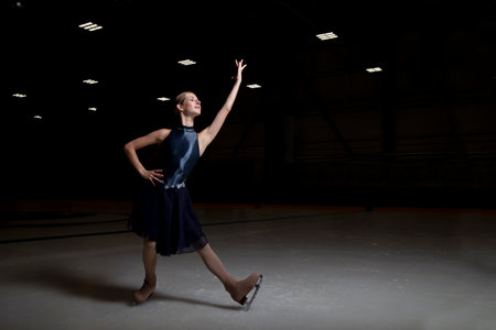 young woman figure skater on a dark backgroundの写真素材