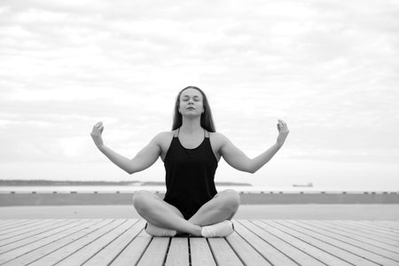 young athletic healthy girl doing yoga by the seaの写真素材