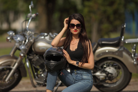 Portrait of charming young woman on a motorcycle