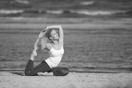 Woman doing yoga at the sea. Beauty fitness womanの写真素材