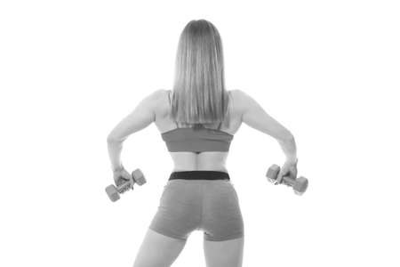 Beautiful fitness woman lifting dumbbells on a white backgroundの写真素材