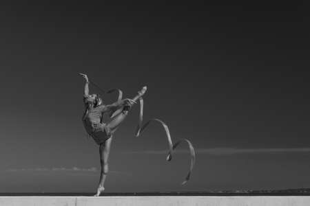 sports woman rhythmic gymnast with red ribbon