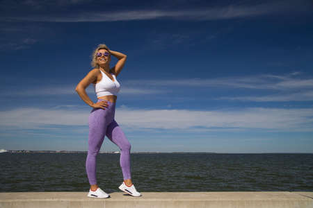Yoga woman in sportswear relaxing by seaの写真素材