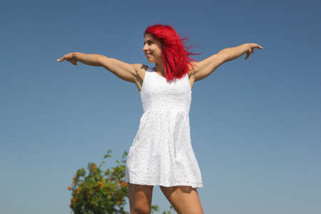 happy girl in a white dress by the seaの写真素材