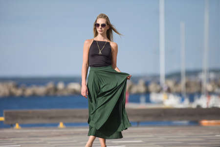 young slender woman by the sea posing in clothesの写真素材