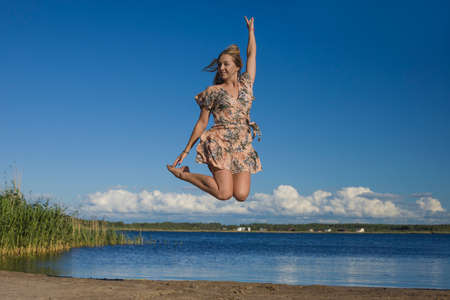 young slender woman by the sea posing in clothes