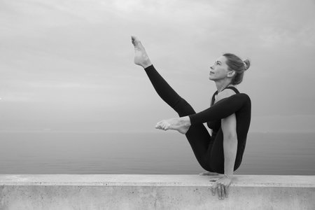 young beauty girl do exercises in summer by the seaの写真素材