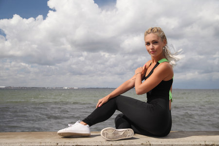 young beauty sports woman sitting in sportswearの写真素材