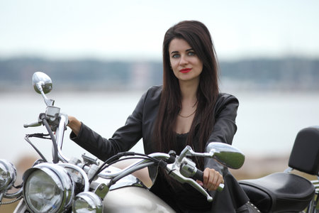 Portrait of charming young woman on motorcycle