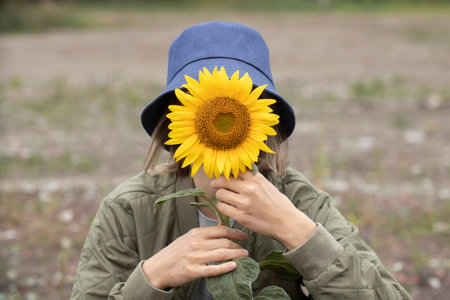 portrait of a young woman in a field with sunflowerの写真素材