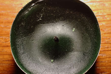 Green candle on brown tableの写真素材