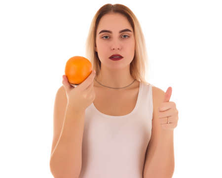 Young cute girl with orange, isolatedの写真素材
