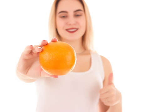 Young cute girl with orange, isolatedの写真素材