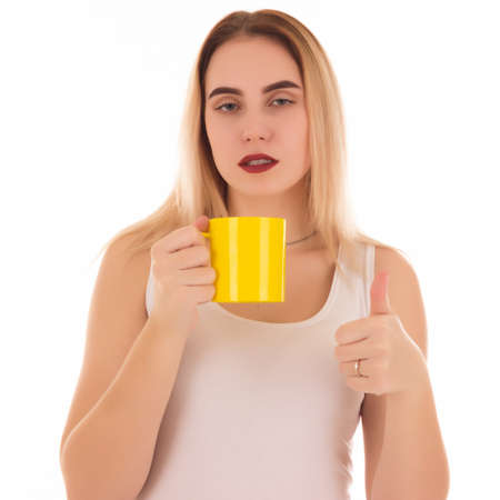 Young cute woman drinks coffee or tea, isolatedの写真素材