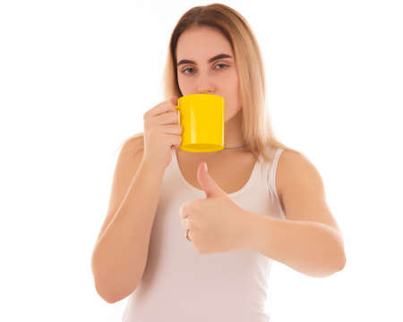 Young cute woman drinks coffee or tea, isolatedの写真素材