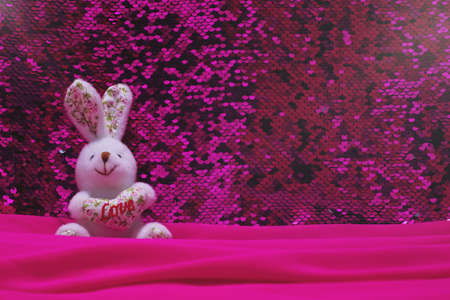 A stuffed rabbit with a heart. A white eared rabbit toy with a heart and the inscription love sits...