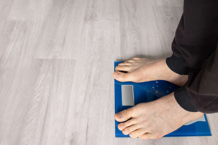 Stand at home on the scale to measure your weight.の写真素材