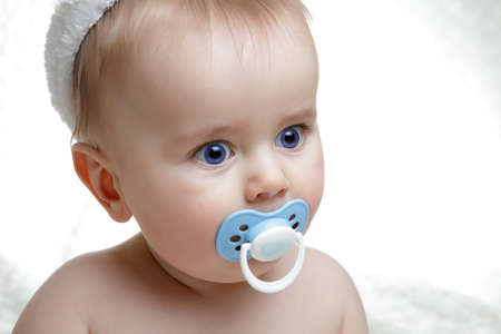 adorable baby with pacifier in mouth looking at camera