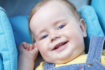 portrait of happy looking little boy with blue eyesの写真素材
