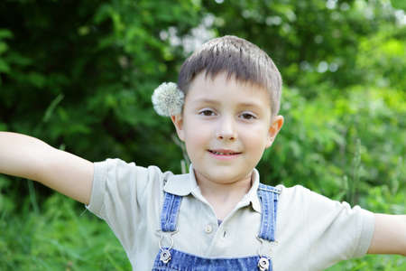 The boy with a dandelion on a green backgraundの写真素材