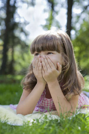 cute young girl plaing on green grassの写真素材