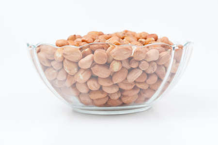 Peanuts in the glass  bowl isolated on white backgroungの写真素材