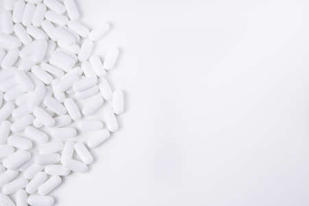 High key shot of white pills brightly lit on white backgroundの写真素材