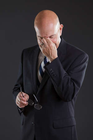 businessman in dark blue suit tiredの写真素材