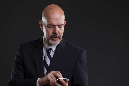 businessman in suit holding smartphoneの写真素材
