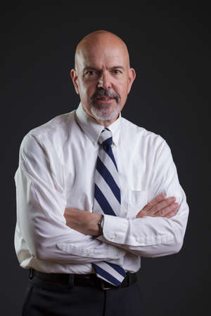 Businessman in white shirt and big strip tie looking serious.の写真素材