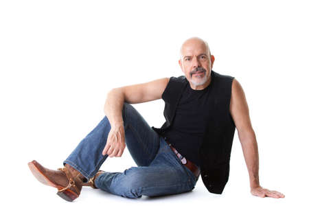 Mature biker sitting on the ground and smiling,  isolated on whiteの写真素材