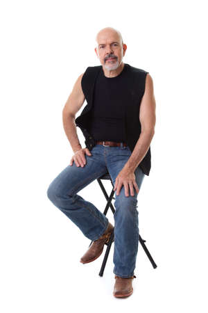 Mature biker sitting on the chair, smiling, isolated on whiteの写真素材