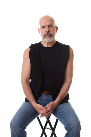 Mature biker sitting on the chair, looking into the camera, isolated on whiteの写真素材