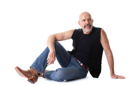 Mature biker sitting on the ground, happy looking, isolated on whiteの写真素材