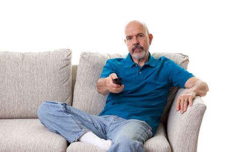Close up Portrait of mature man sitting on the couch using remote isolated on whiteの写真素材