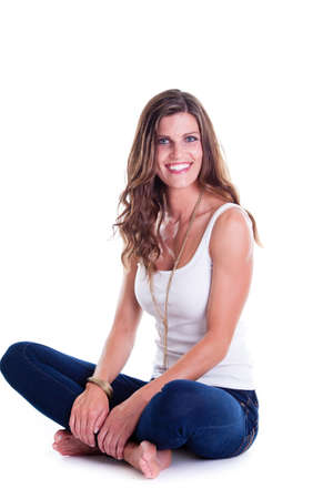 Beautiful woman in jeans and sleeveless shirt, studio portrait. Isolated on white.の写真素材