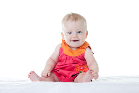 Little cute baby-girl in dress, sitting, isolatedの写真素材