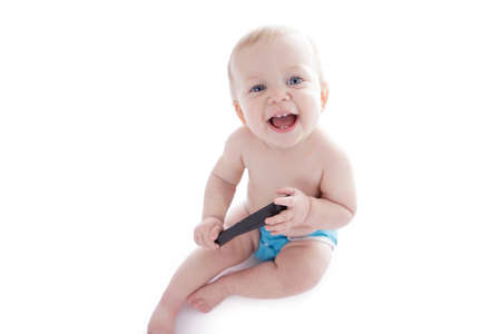 baby in cloth diaper holding tv remote isolated on whiteの写真素材