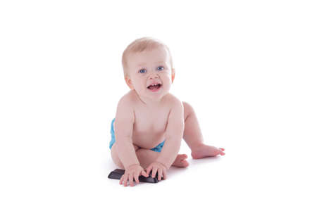 baby in cloth diaper holding tv remote isolated on whiteの写真素材