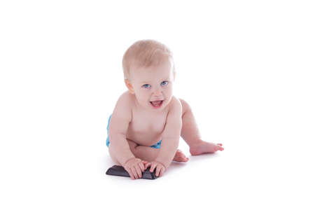 baby in cloth diaper holding tv remote isolated on whiteの写真素材