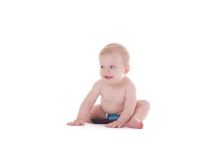 baby in cloth diaper holding tv remote isolated on whiteの写真素材