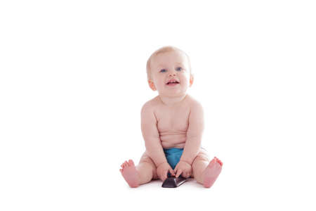 baby in cloth diaper holding tv remote isolated on whiteの写真素材