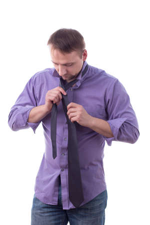 Man tying a tie, in long sleeved shirt, isolated on whiteの写真素材