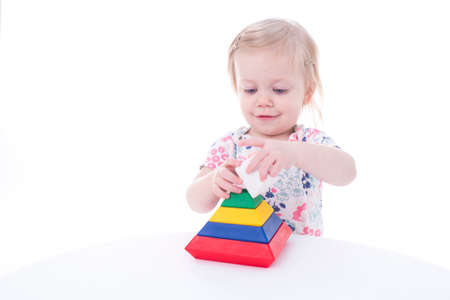 toddler girl stacking blocks, isolated on whiteの写真素材