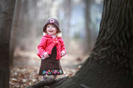 happy little child, baby girl laughing and playing in the fall outdoorsの写真素材