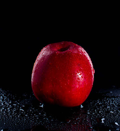 fresh red apple with droplets of water against black background diet, eat, food reflectionの写真素材