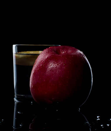 fresh red apple with droplets of water against black background diet, eat, food reflectionの写真素材