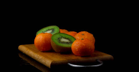 fresh tropical fruits dribble in water kiwi tangerineの写真素材