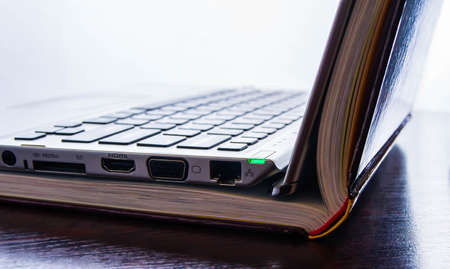 Laptop computer with colored books study, library, technology, online, computerの写真素材