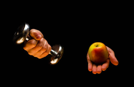 Dumbbells, apple and tape measure. Fitness concept. Isolated on black backgroundの写真素材
